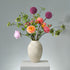 Lush Bloomscape konstblomsbukett med starka rosa, orangea och gröna toner – livfullt arrangerad med silkesblommor och blad. FLORISSMA