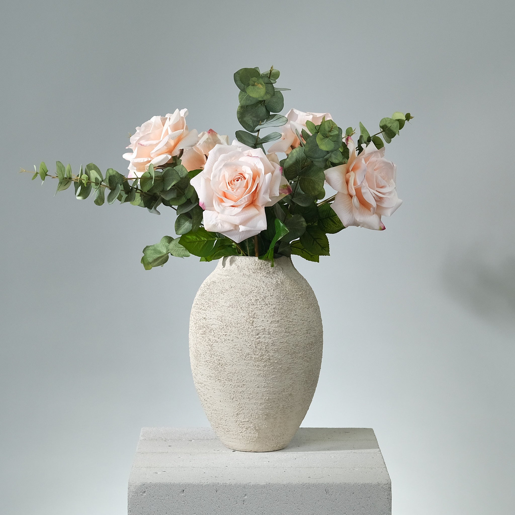Romantisk konstblomsbukett Rose Petal Dream med silkesblommor i vinröda och rosa toner, arrangerad i vas mot ljus bakgrund