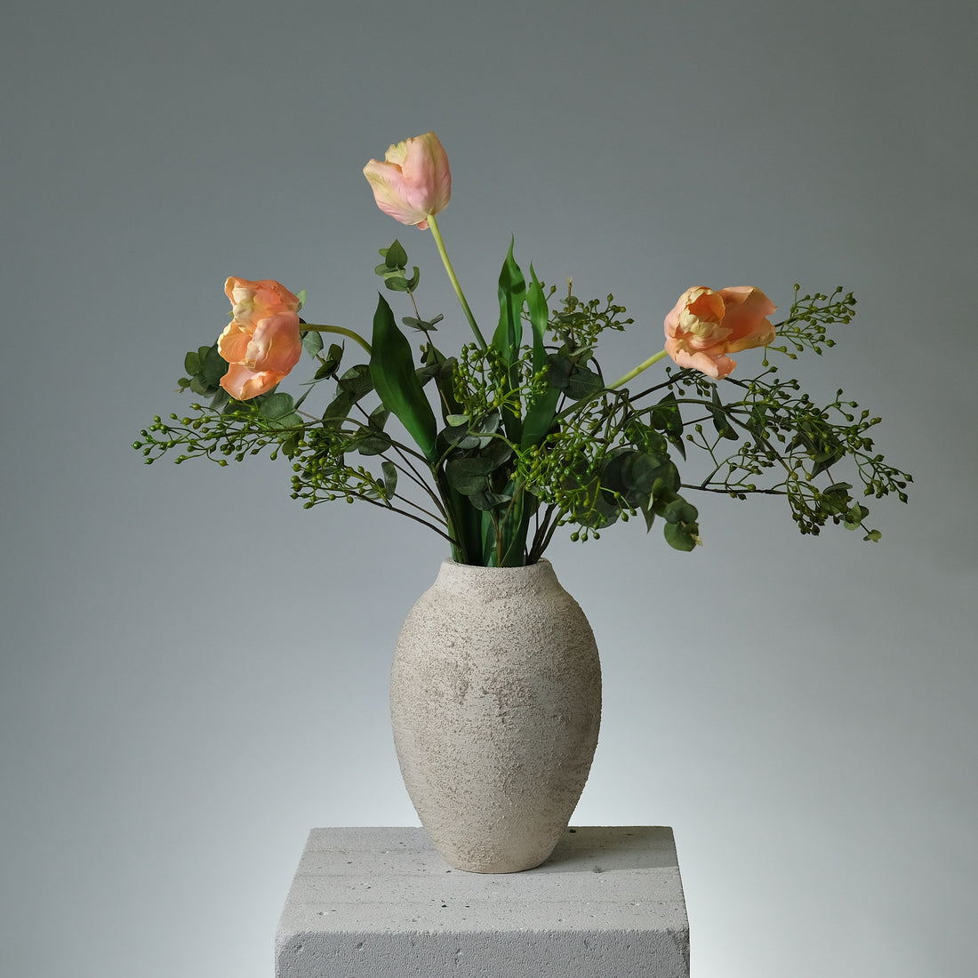 Bukett i konstblommor med rosa/krämfärgade tulpaner, grön eukalyptus och dekorativa gröna bär – i en naturlig och stilren komposition - FLORISSMA