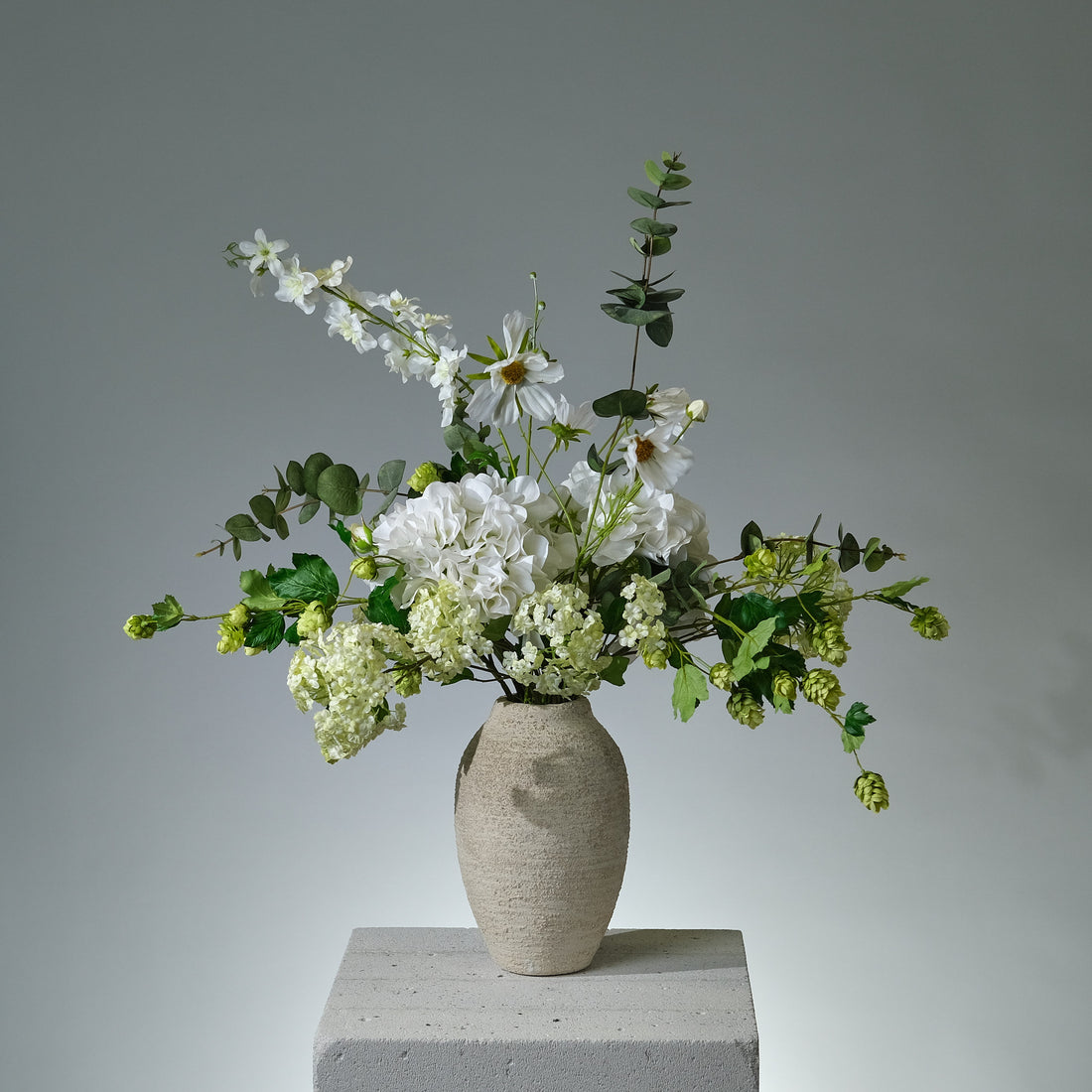 Bukett i konstblommor med vit hortensia, krämfärgad ros, snöboll, eukalyptus, humle och andra gröna blad i naturlig och stilren komposition - FLORISSMA