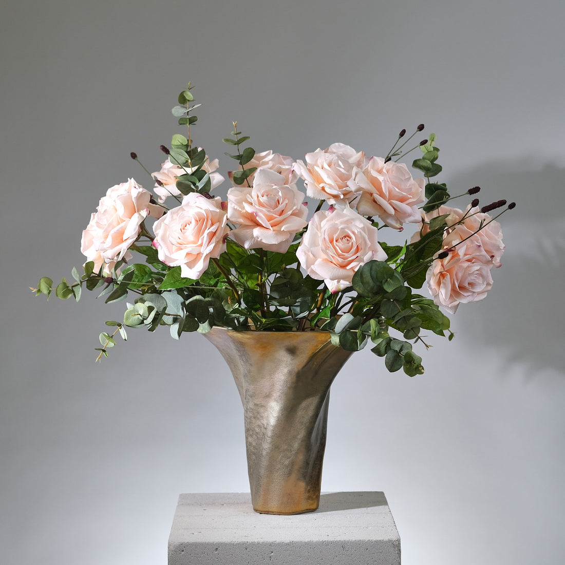 Stor konstgjord bukett Rosy Riviera med exklusiva rosor i rosa och aprikos nyanser, arrangerad med gröna blad i en stilren vas.